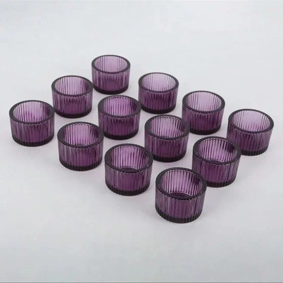 Set of purple ribbed glass candle holders on a white background