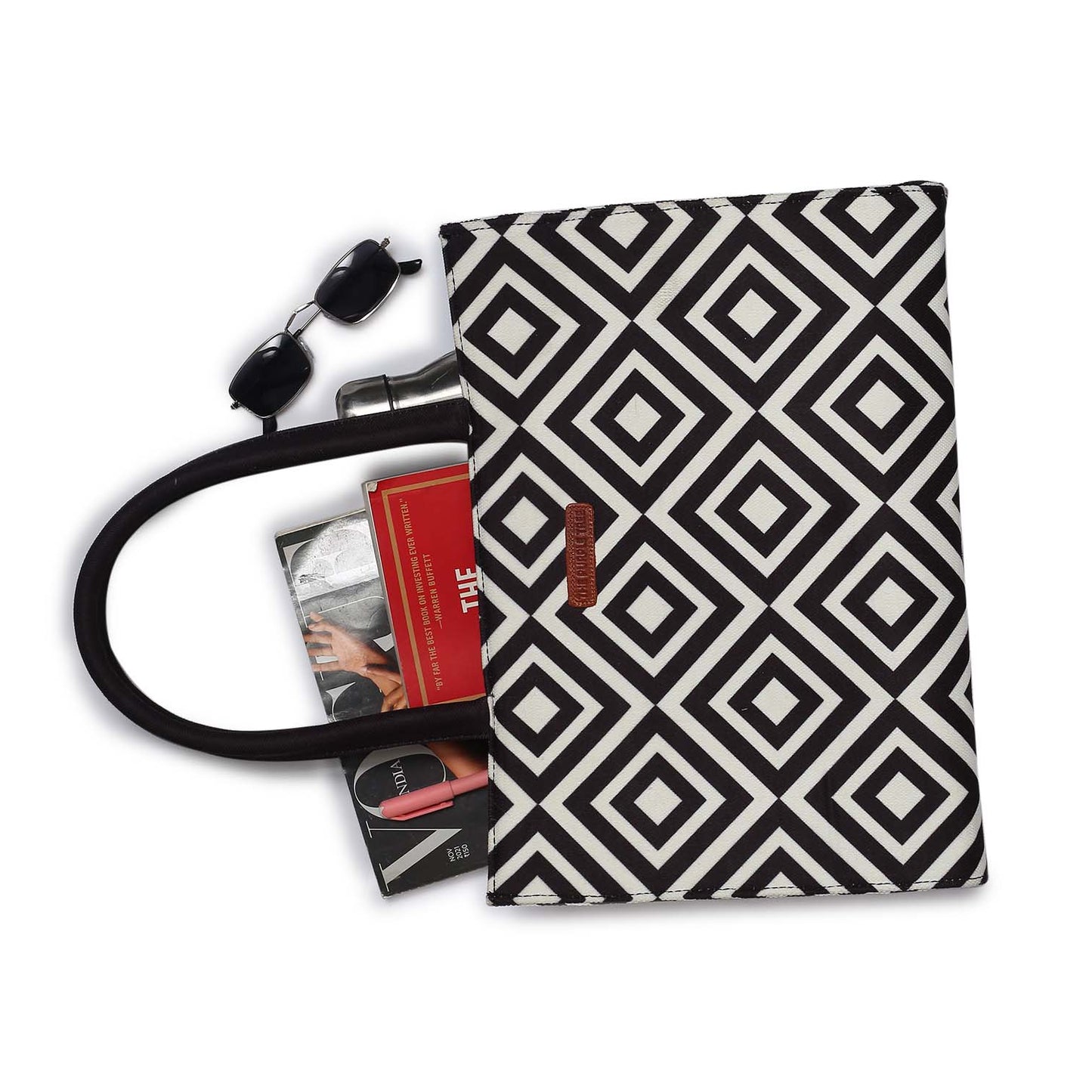 Look at this fabulous bag! It's adorned with a black and white pattern and comes with a book and a glass of water.