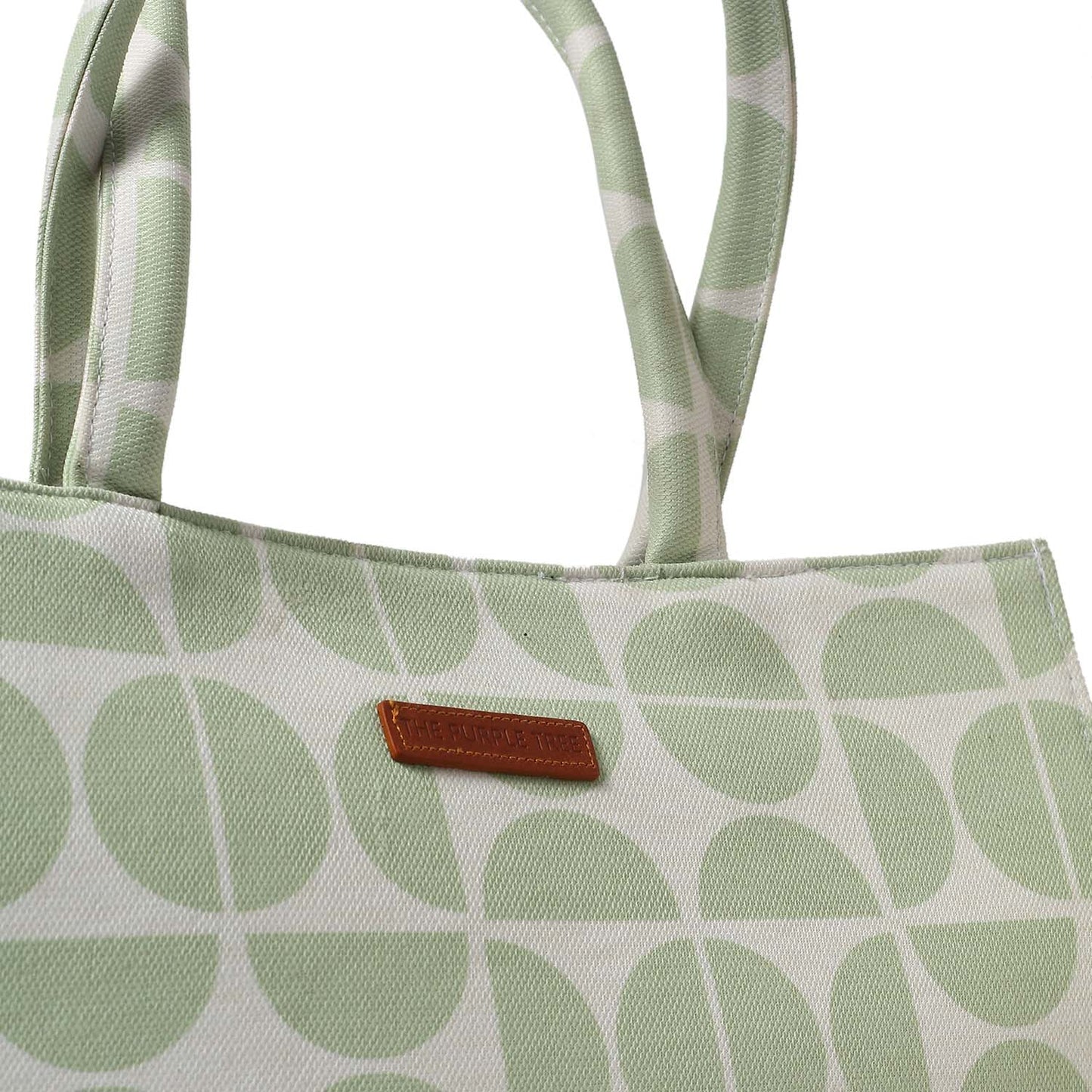 A stylish green and white tote bag with book and notebook.