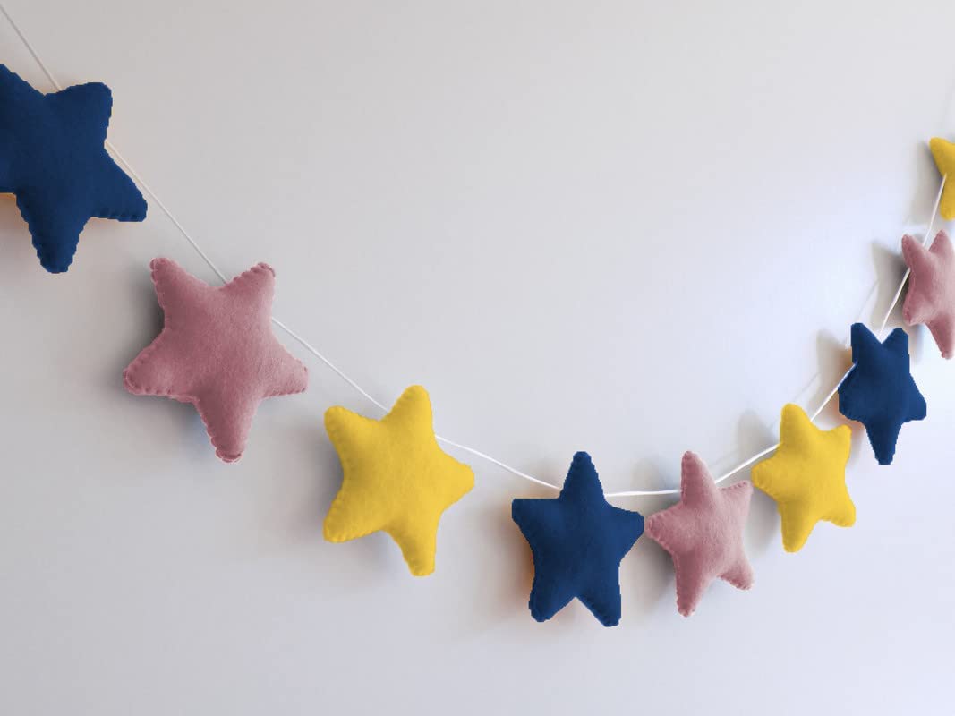 Colorful felt star garland hanging on wall.