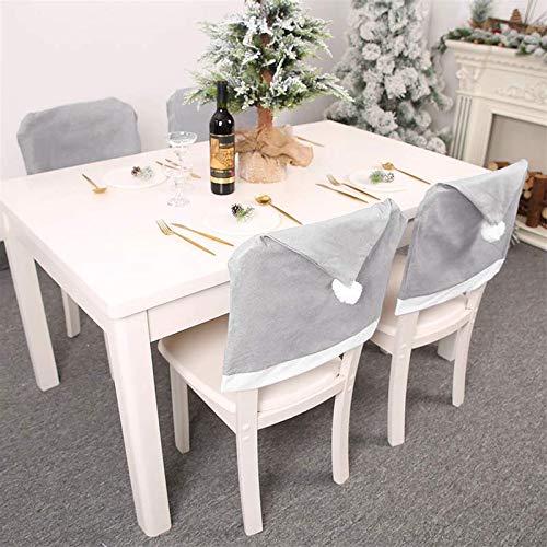 A festive scene with a table, four chairs, and a Christmas tree.