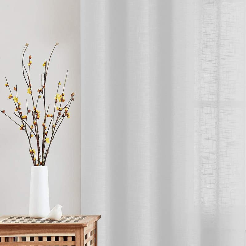 Wooden table with white linen curtains draped over it.