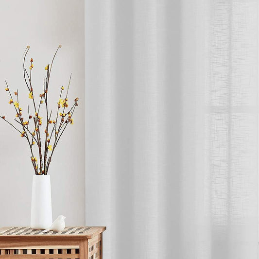 Wooden table with white linen curtains draped over it.