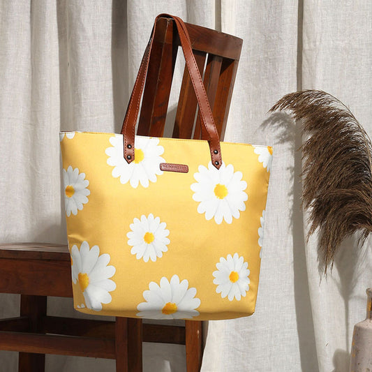 Yellow tote bag with white daisies, perfect for carrying essentials on a sunny day out.