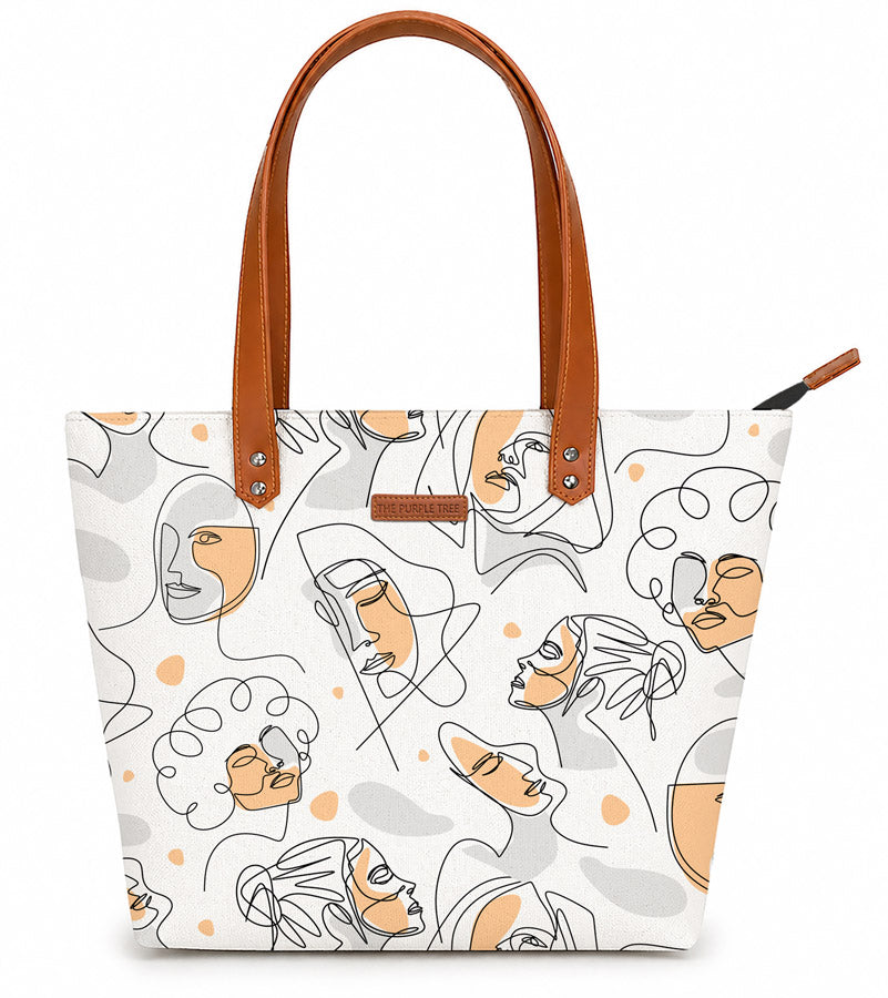 Tote bag with abstract face design and brown handle on a white background
