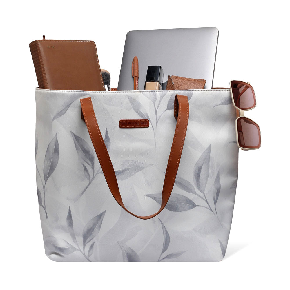 A chic tote bag featuring a leaf print in white and gray.