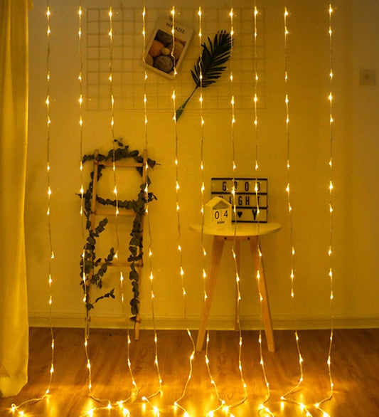 Cozy room with a curtain of string lights creating a warm and inviting atmosphere.