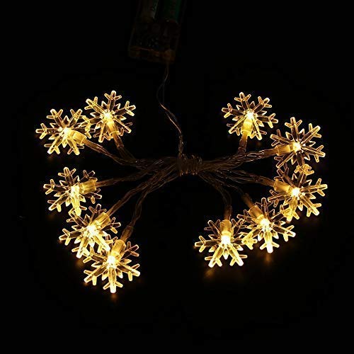 Glowing snowflake LED Christmas lights bringing a festive glow to the winter landscape.