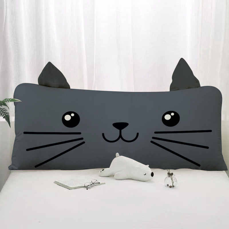 Adorable cat pillow with a stuffed animal perched on it.
