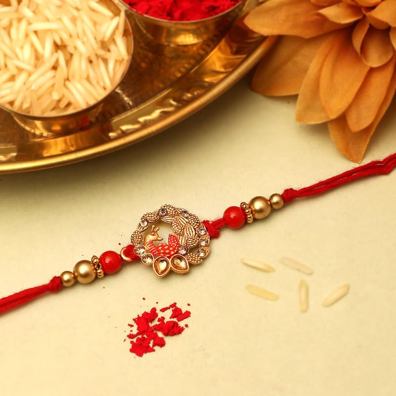 Traditional rakhi with red and gold thread, adorned with a shiny gold bead.