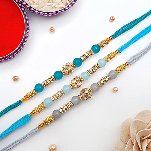 Elegant blue and gold rakhi adorned with a sparkling crystal bead.