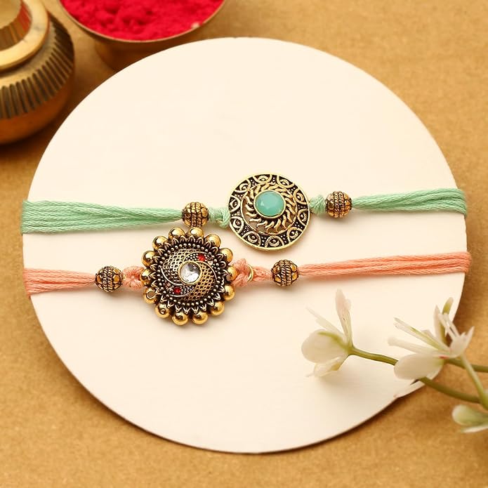 A pair of rakhi made with vibrant gold and green threads, representing the bond of sibling love and care.