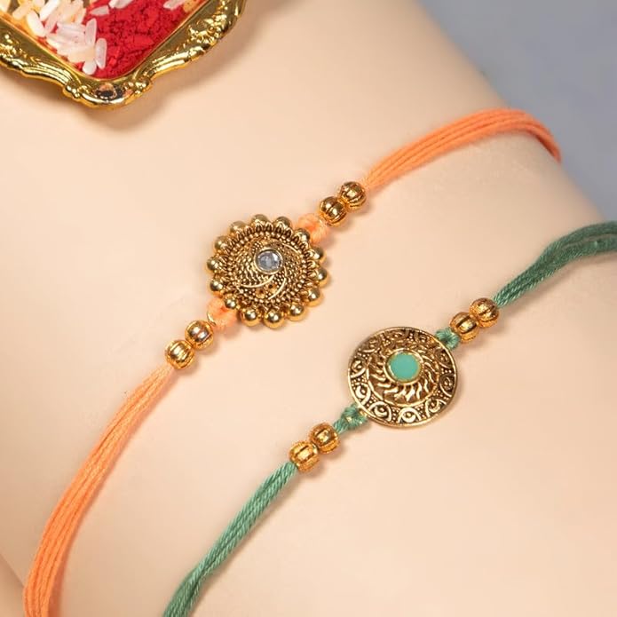 A pair of rakhi bracelets made with vibrant gold and green threads, representing the bond of sibling love and care.