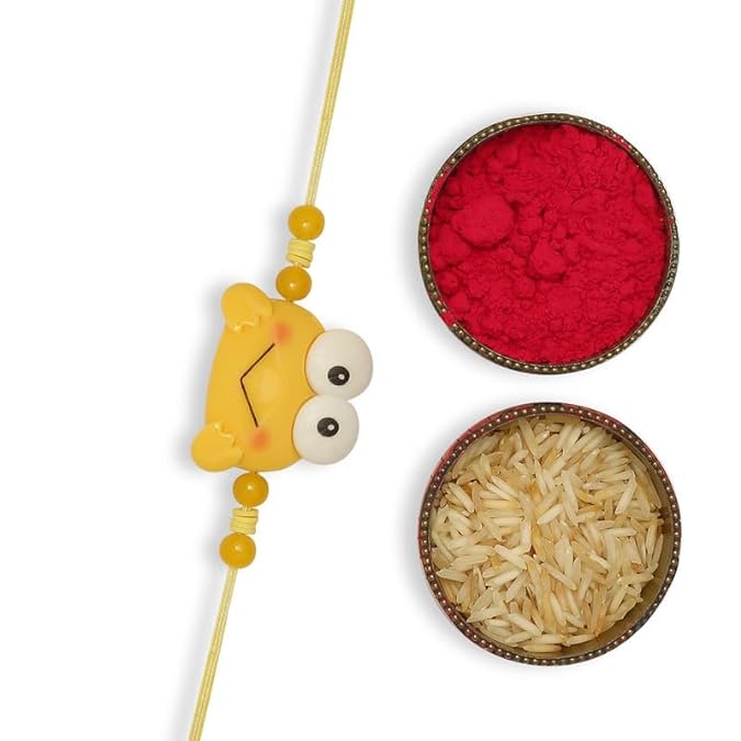 A yellow rakhi with a vermilion and a bowl of rice, symbolizing the festive celebration of Raksha Bandhan.