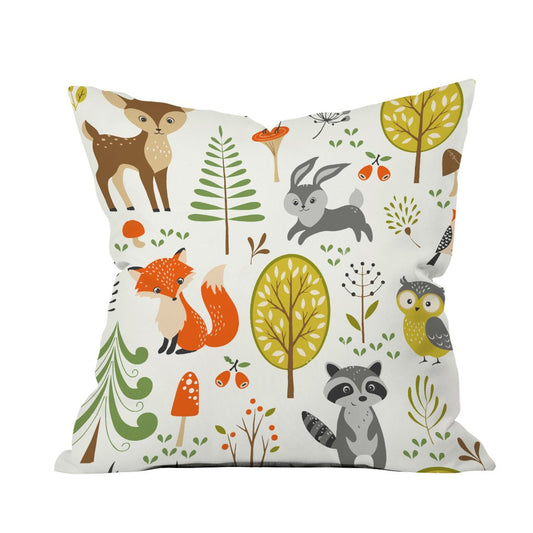 A decorative pillow featuring charming woodland animals surrounded by trees in a serene natural setting.