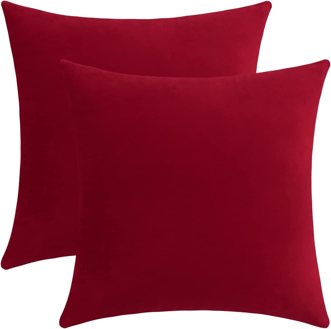 A duo of red velvet pillows on a white background, illustrating their elegant design and luxurious fabric.
