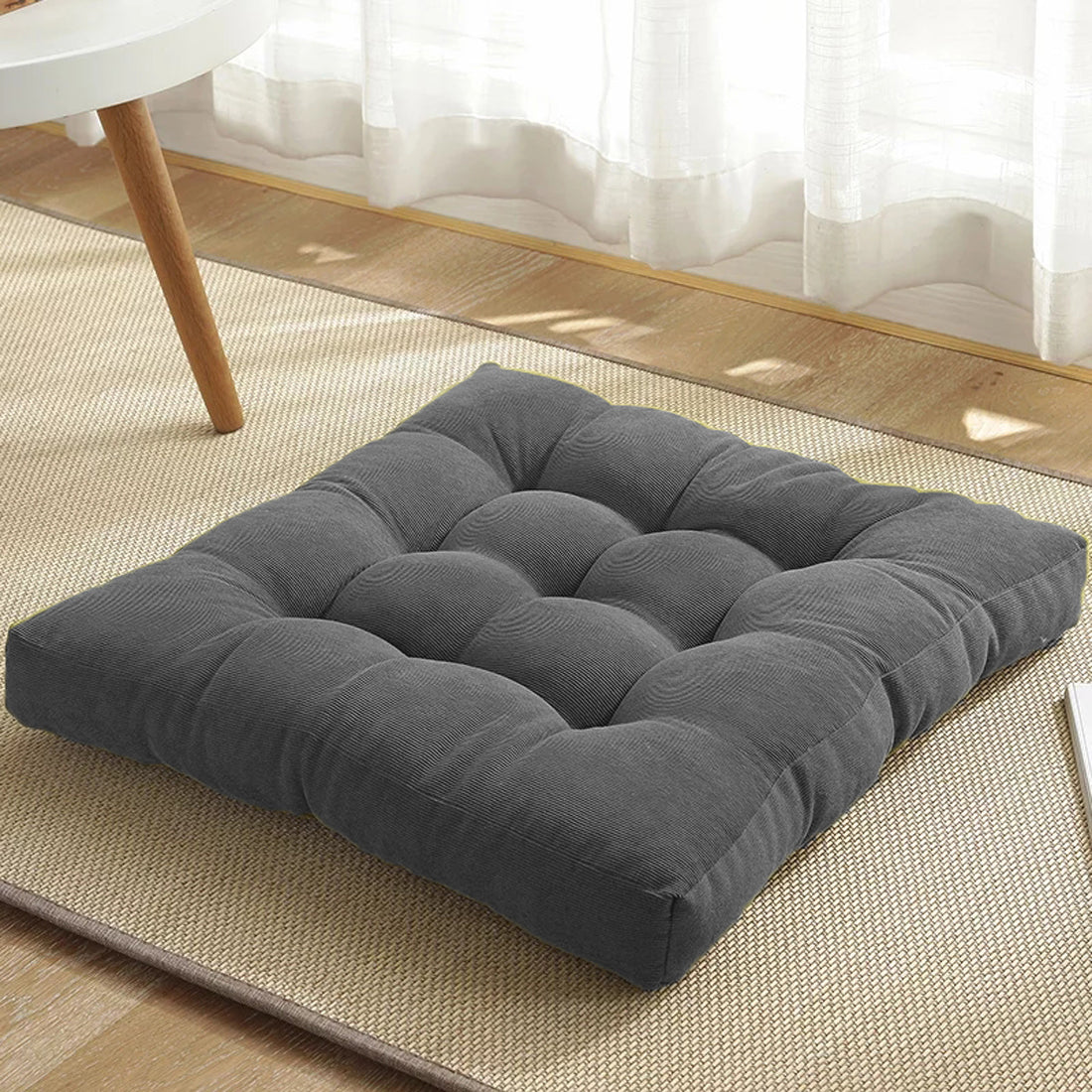 Gray cushion resting on rug.