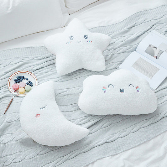 Three white pillows with smiling faces and fluffy cloud designs, adding a touch of whimsy to any space.