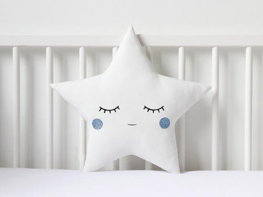Two white pillows with blue eyes and a star on top, perfect for adding a touch of whimsy to your bedroom decor.