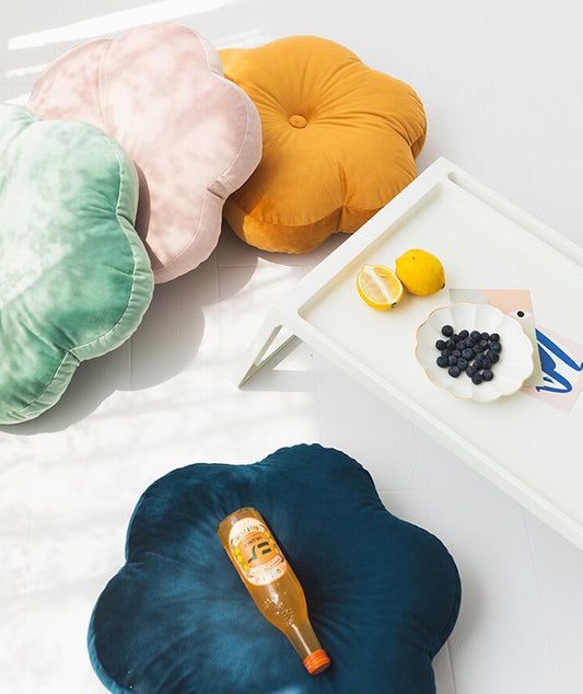 Bright yellow floral cushion resting on a clean white table surface.
