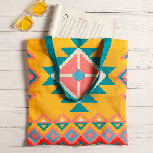 A vibrant yellow and blue tote bag adorned with a delightful pink and turquoise design.