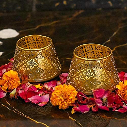 Two gold tea lights on marble table.