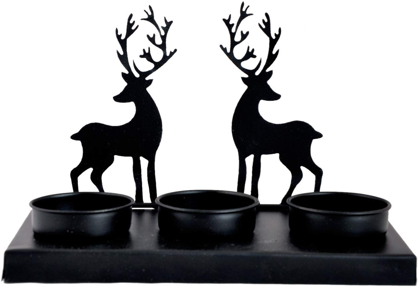 Two deer shapes highlighted by a flickering candle.