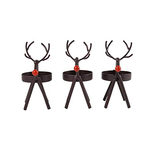 Black reindeer candles on a table with a red pillow.