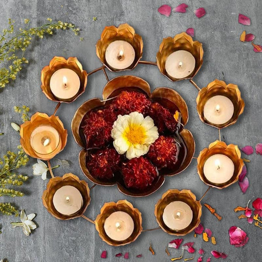 Diwali diya surrounded by gold and silver flowers.