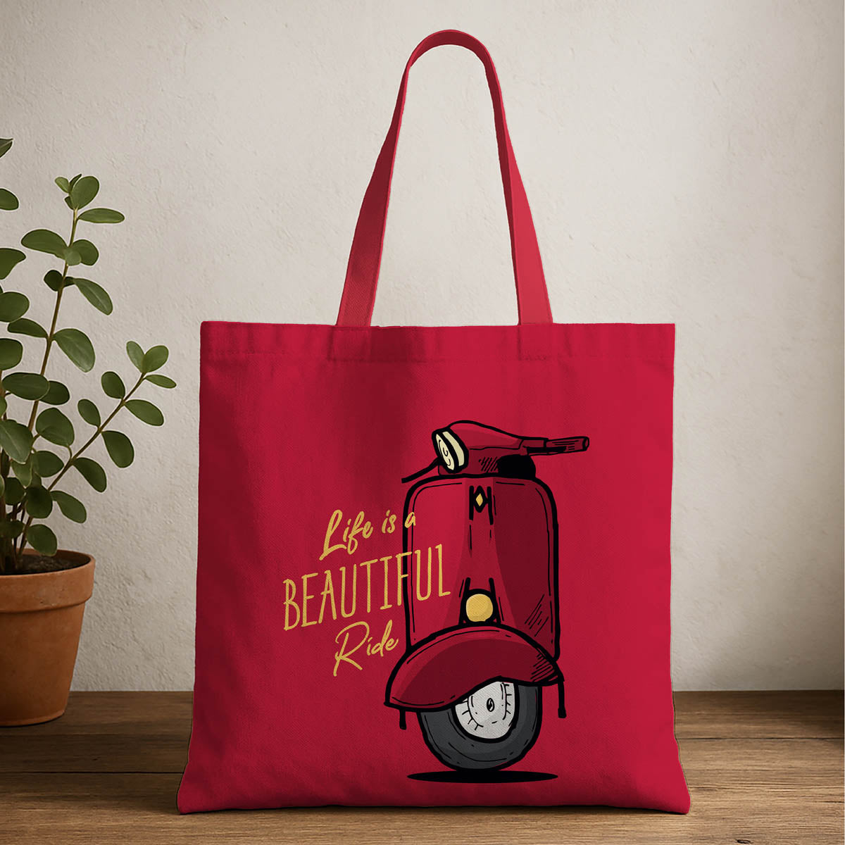 A red tote bag featuring a graphic of a scooter printed on its surface.