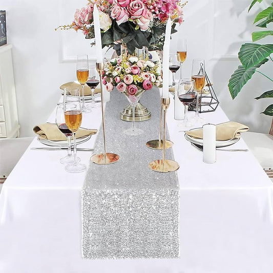 Stylish silver sequin table runner complemented by pretty flowers.