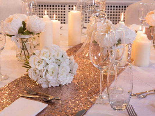 Decorative table with white and pink flowers and candles adding a touch of elegance.