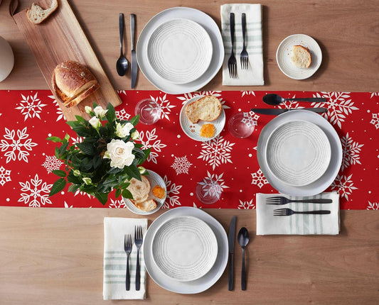 A red table runner drapes over a table, paired with a chair that has a white snowflake design.