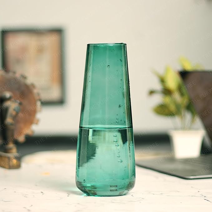 A table showcasing a green glass vase.