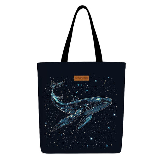 A tote bag featuring a whale design surrounded by stars on a light background.