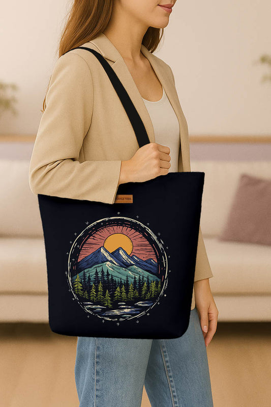 A black tote bag adorned with an illustration of a mountain scene.