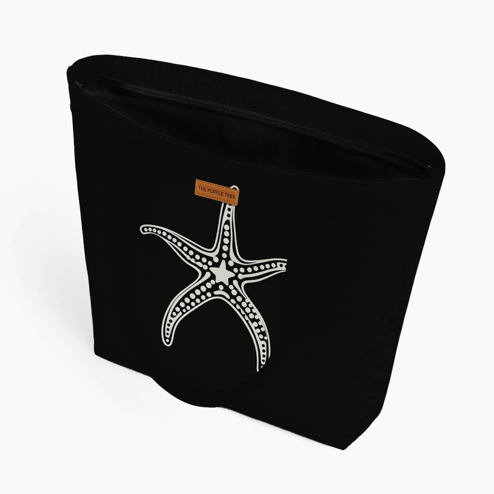 A black tote bag showcasing a starfish graphic, suitable for everyday use or beach trips.