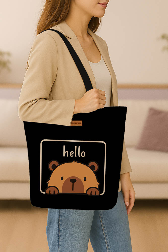 A stylish tote bag adorned with a cheerful bear graphic and the words "hello" in playful lettering.