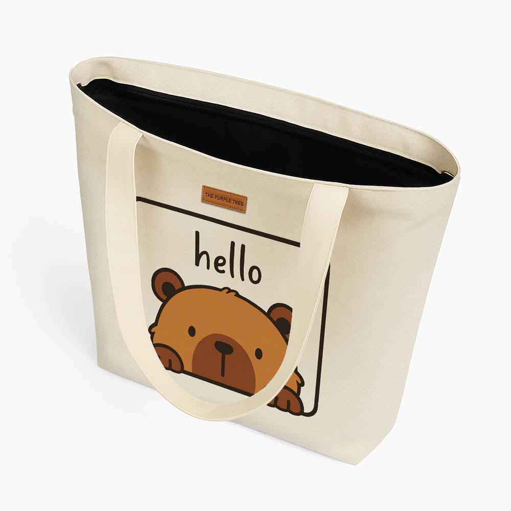 A tote bag showcasing a cute bear illustration alongside the word "hello."