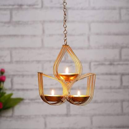 Decorative gold hanging lamp with three candle holders on a dark background