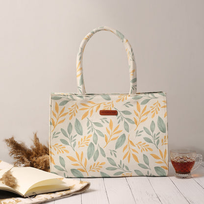 Yellow and green leaf print tote bag, perfect for carrying essentials in style.