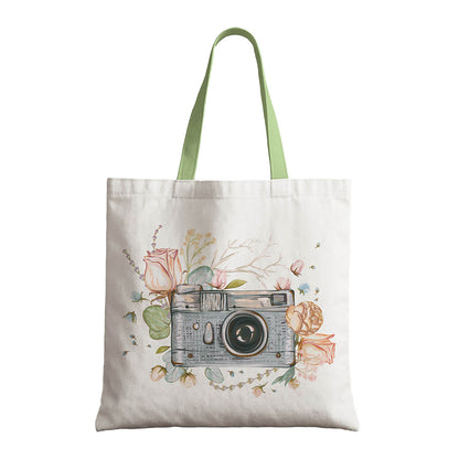 A tote bag that features a camera photo surrounded with flowers representing a blend of fashion and photography