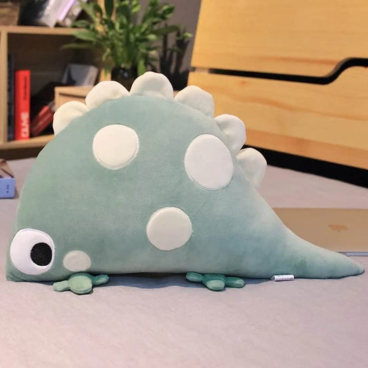A stuffed dinosaur toy sitting on a desk, adding a touch of whimsy to the workspace.