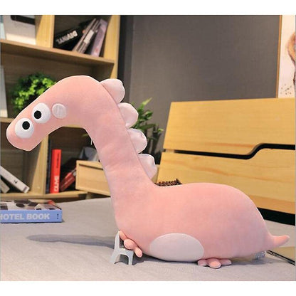 A cute pink dinosaur toy resting on a bed