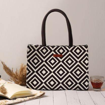 A black and white patterned bag with a book and a glass of water, perfect companions for a stylish and relaxing day.