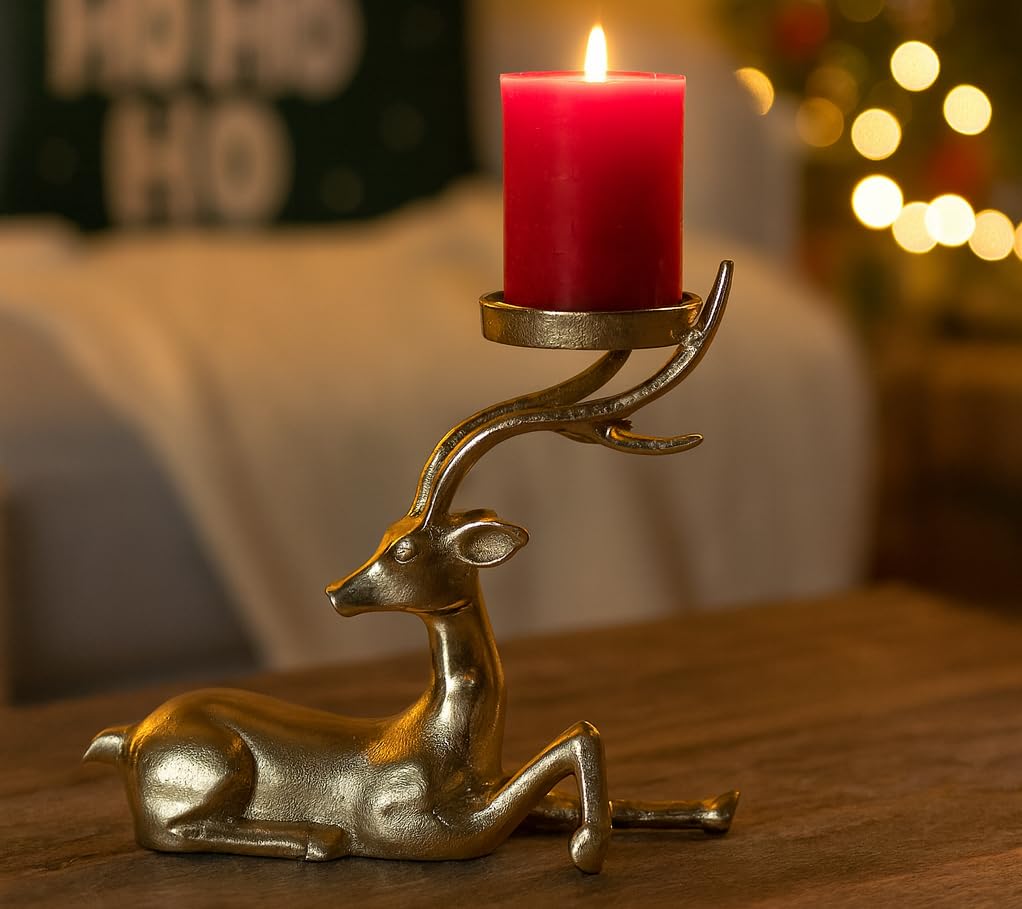 Decorative deer-shaped candle holder with a red candle on a wooden surface.