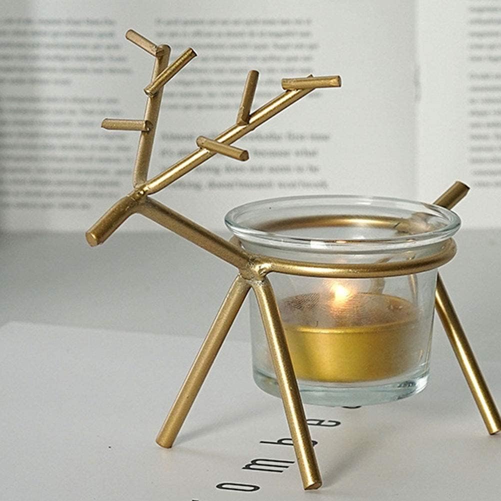 Gold branch-like candle holder with a lit candle inside on a white surface.