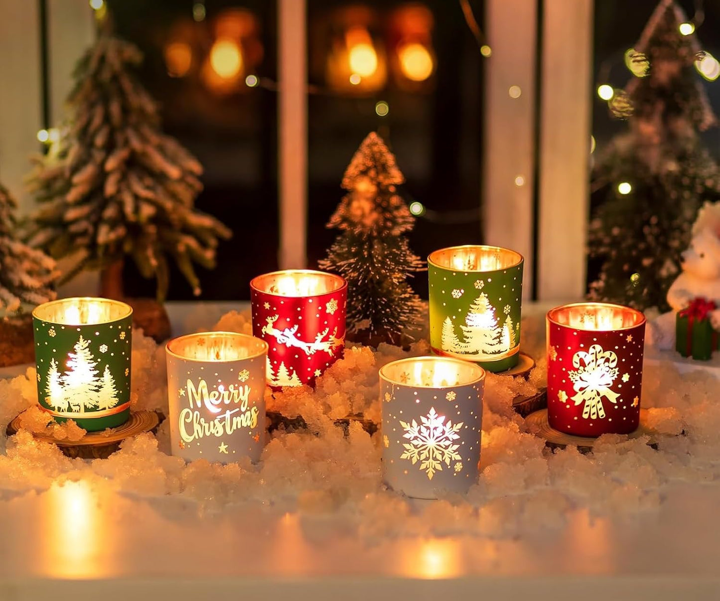 Decorative candles with Christmas designs on a snowy surface