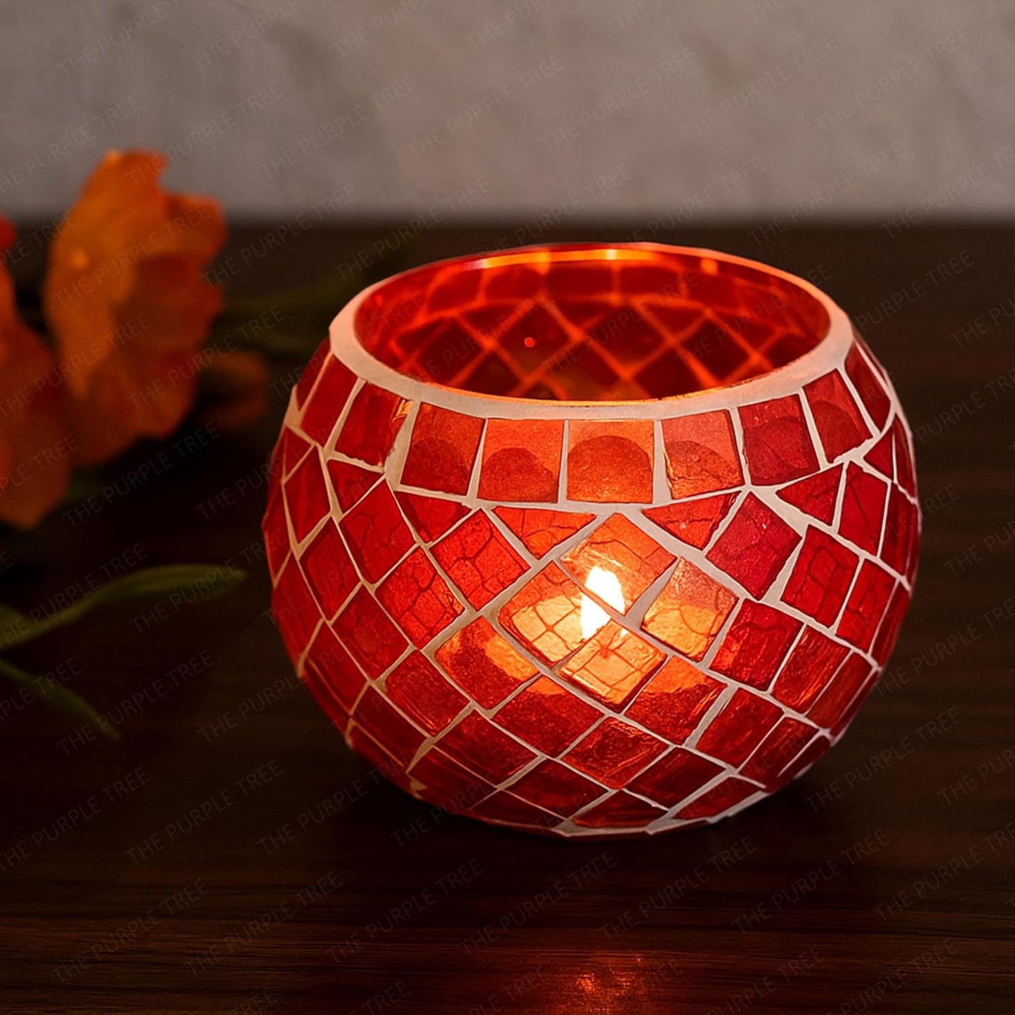Two red glass tealights glowing on a table