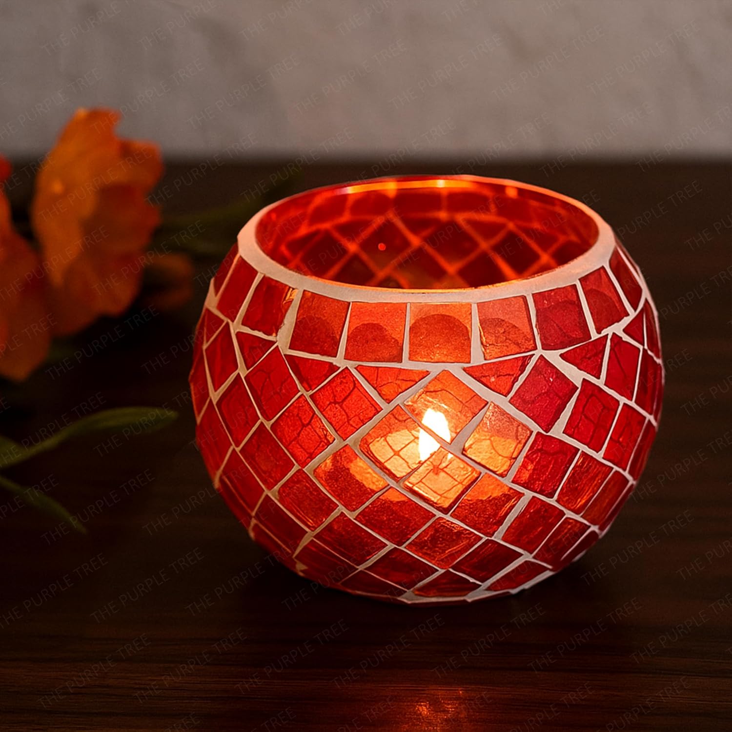 Two red glass tealights glowing on a table